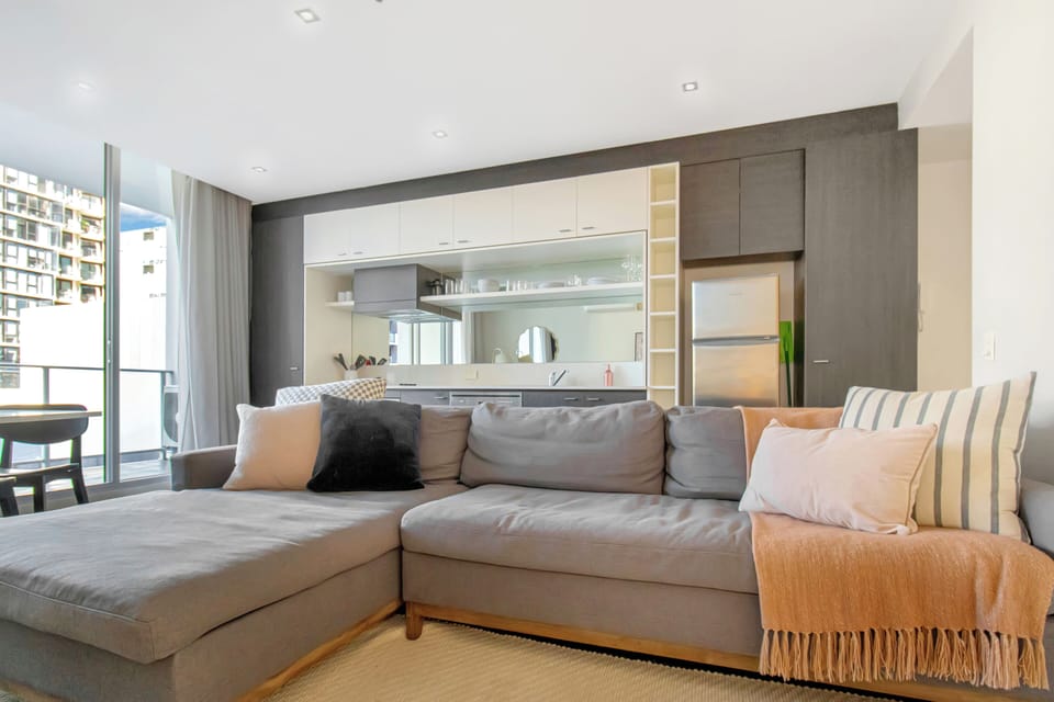 Bright modern living area with plush sectional and sleek open kitchen