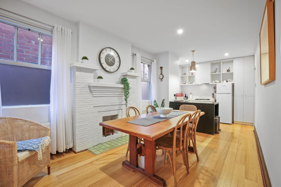 Charming open-plan kitchen & dining with retired fireplace and hardwood floors