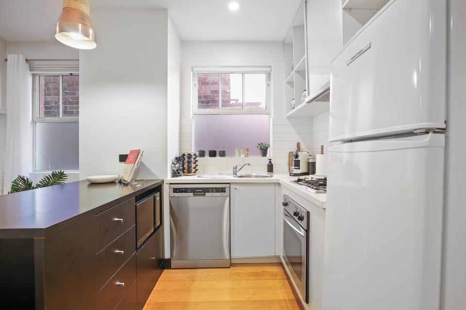 Bright, modern kitchen with gas cooktop, dishwasher, and island.