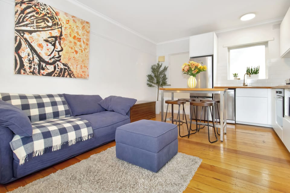 Bright open-plan lounge and kitchen with stylish decor and warm timber floors
