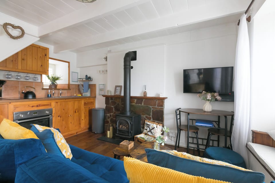 Cosy living space with traditional stone fireplace, gas stove and Smart TV