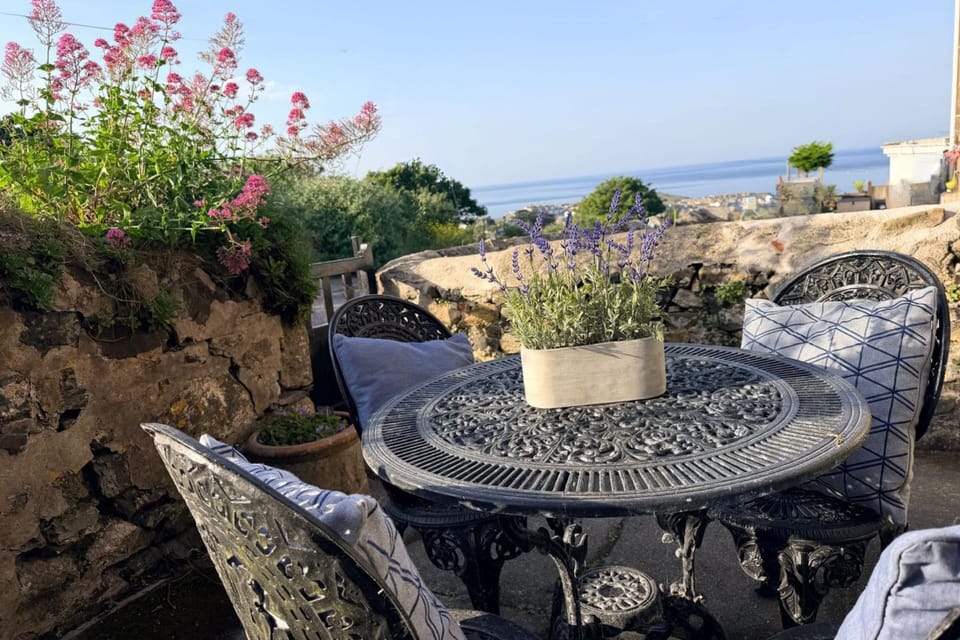Private courtyard dining area with partial sea views