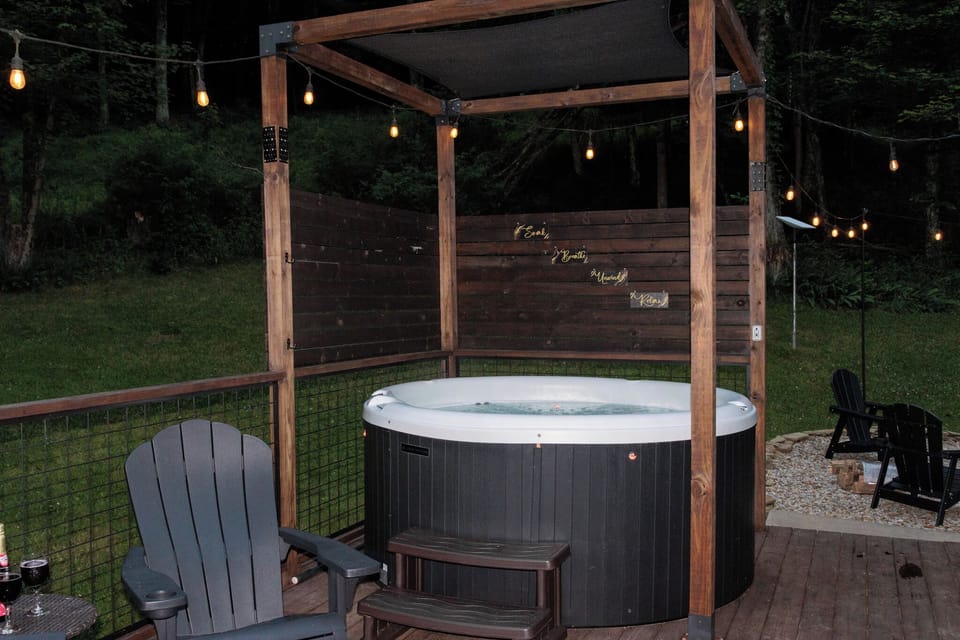 Private covered hot tub with string lights and peaceful wooded views