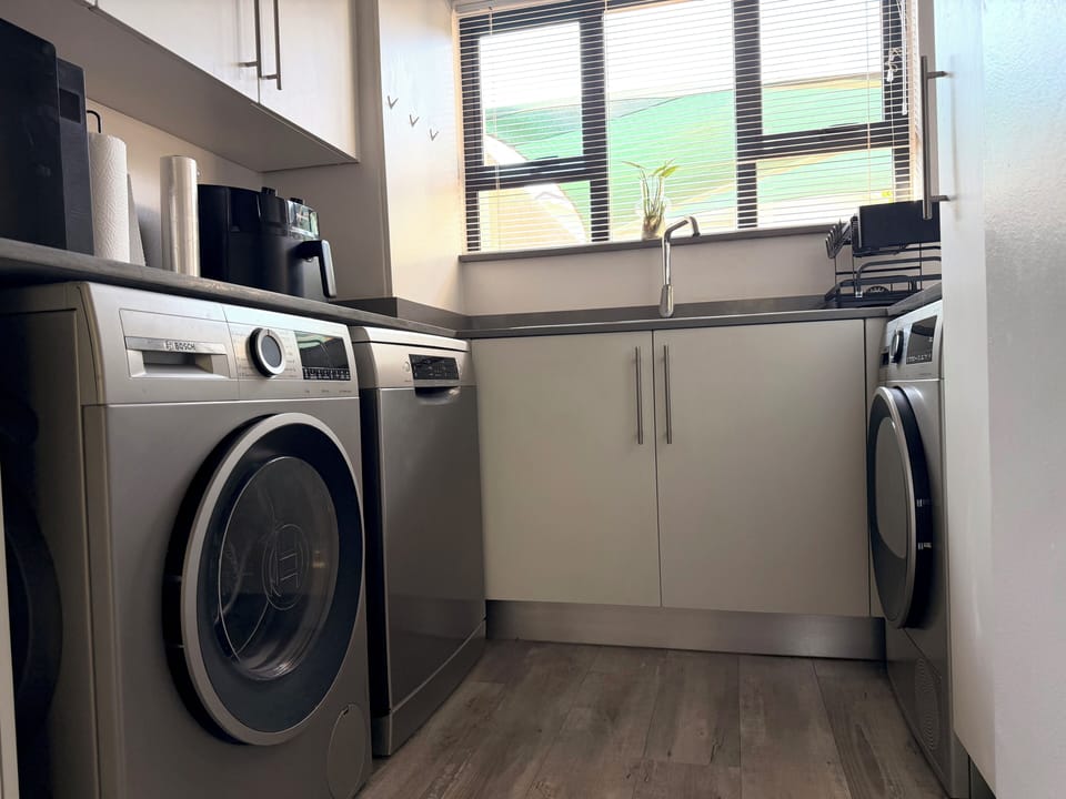 Kitchen utility area with washer, dryer, and dishwasher.