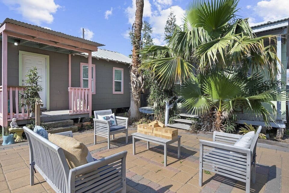 Sunny courtyard with lounge seating &amp; palms—perfect for games.