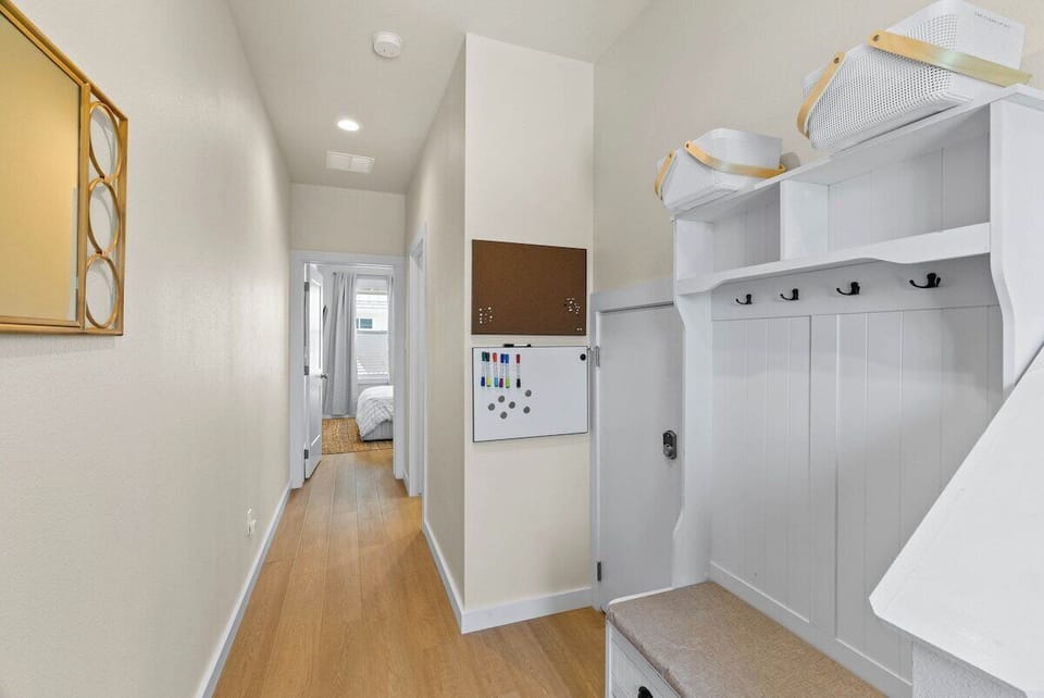 Entryway drop zone with hooks, baskets, and a family message board—perfect for organizing your beach gear during your stay.