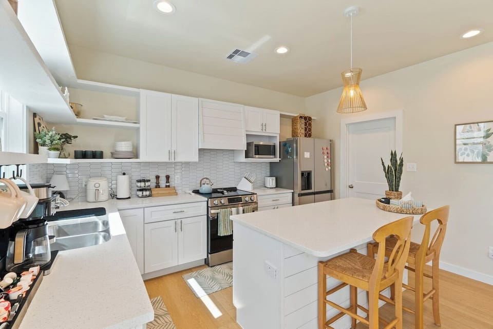 Another angle of the modern kitchen with stainless steel appliances and a cozy island seating area.