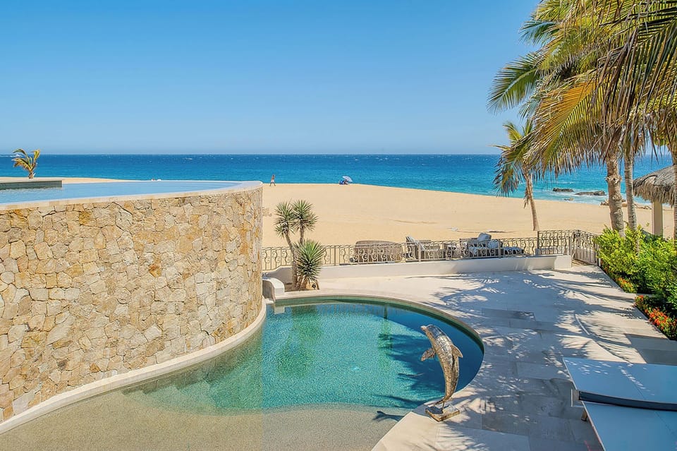 Your private pool awaits with unobstructed beach and ocean views, framed by swaying palms and golden sand—a serene tropical escape just steps from the shore.