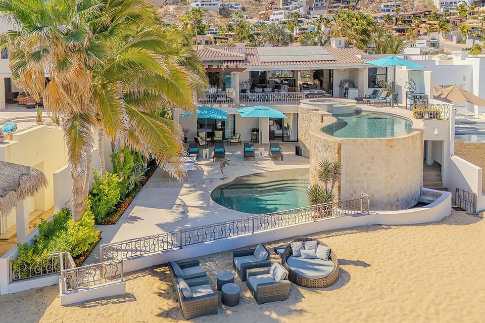 Spectacular hillside villa with multiple pools and terraces set against a scenic coastal backdrop, offering luxurious indoor-outdoor living spaces throughout the property.