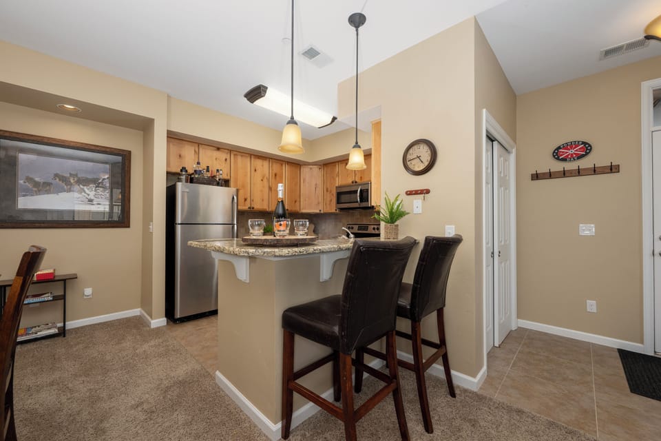 Gather at the breakfast bar in your open kitchen with granite counters, stainless appliances, and warm wood cabinetry—perfect for morning coffee or casual dining after a day of adventure.