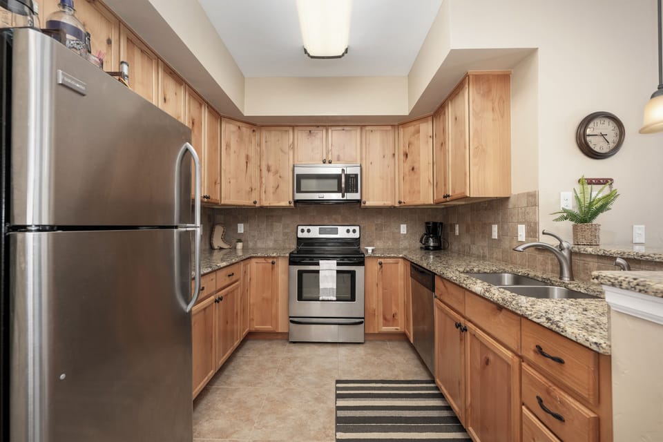 Your fully equipped kitchen features warm wood cabinetry, granite counters, and stainless steel appliances—everything you need to whip up a home-cooked meal during your stay.