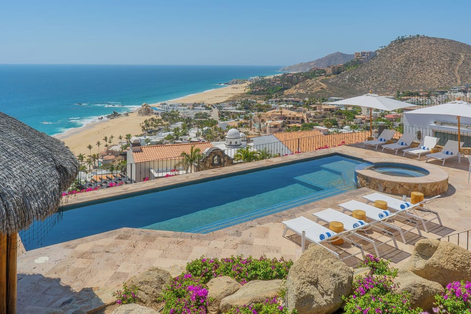 Stunning oceanfront property featuring infinity pool with panoramic views of pristine beaches and dramatic coastal mountains.