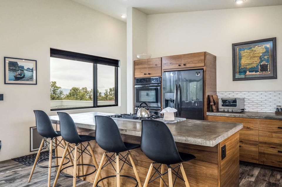 Kitchen with a concrete island, gas cooktop, and bar seating