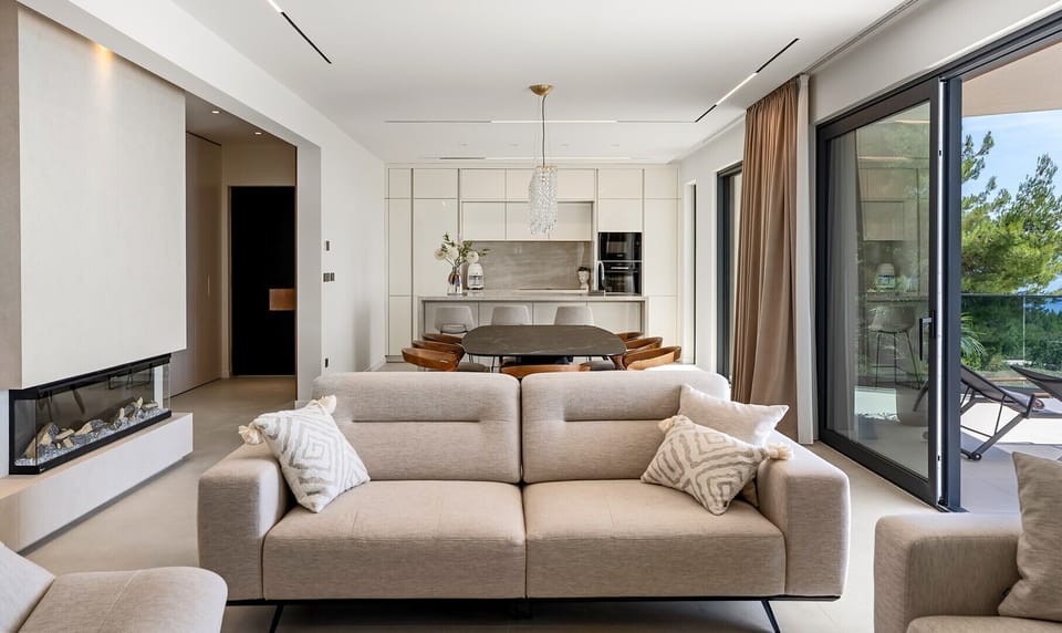 Fully furnished main living zone combining a sofa lounge, TV, and fireplace.
