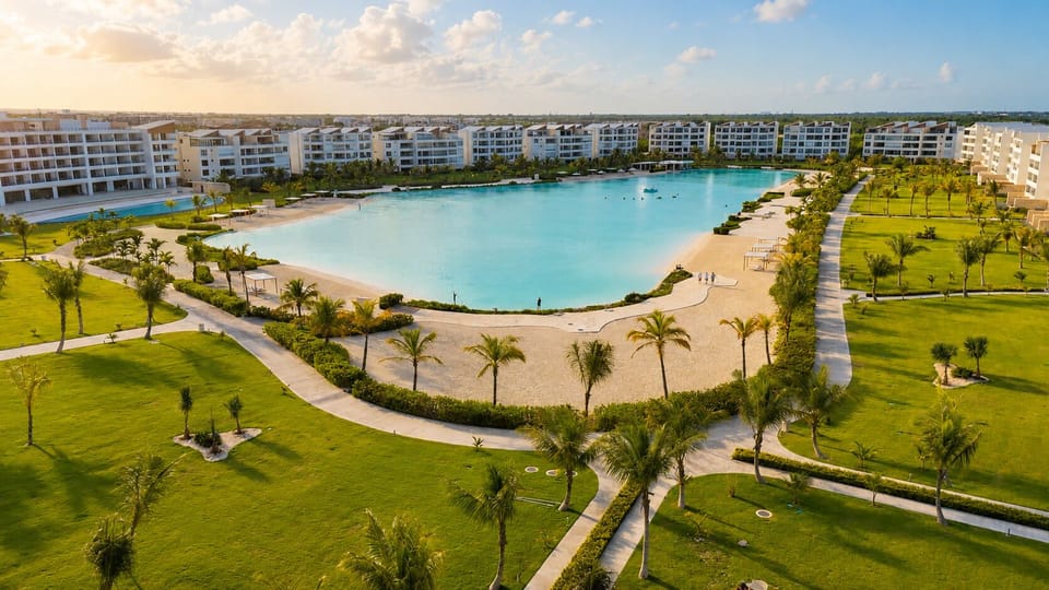 Expansive Crystal Lagoon pool area with sandy beach and lush landscaped gardens, perfect for relaxation.