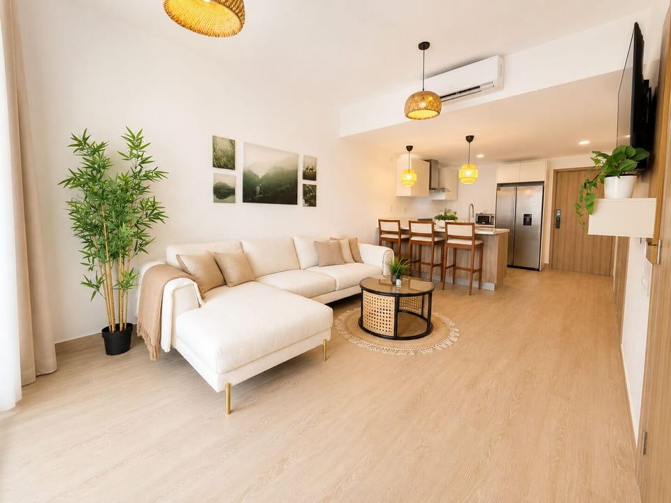 Open-concept living room with cozy sectional sofa and modern kitchen with island seating.