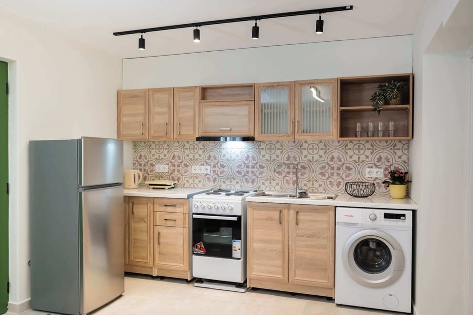 The fully equipped kitchen sits neatly along the wall, with a washing machine that makes longer stays feel easy.