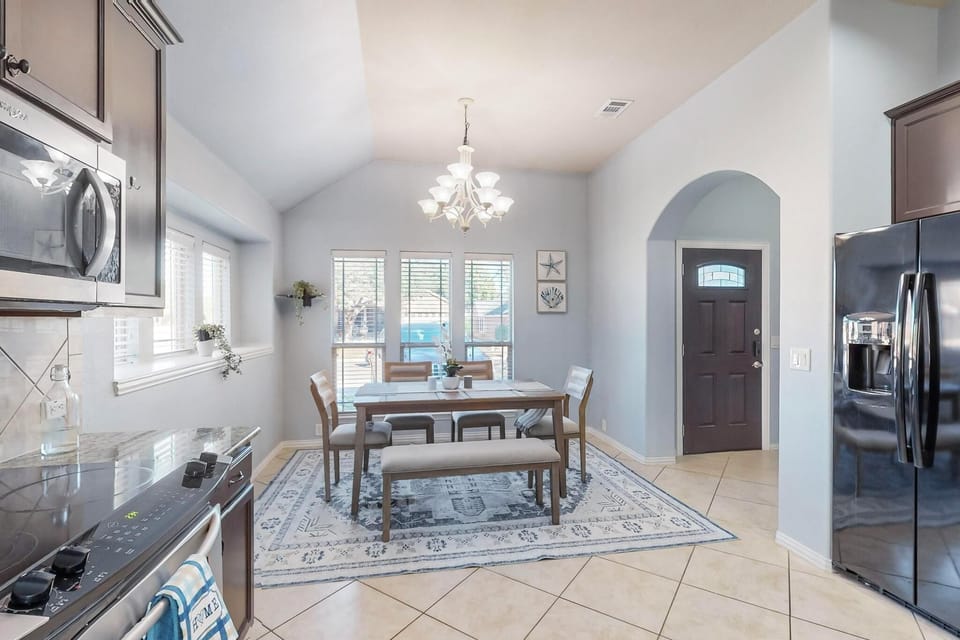Gather around this inviting dining space bathed in natural light from plantation shutters. The open layout flows seamlessly into your fully-equipped kitchen, making meal prep and entertaining a breeze.