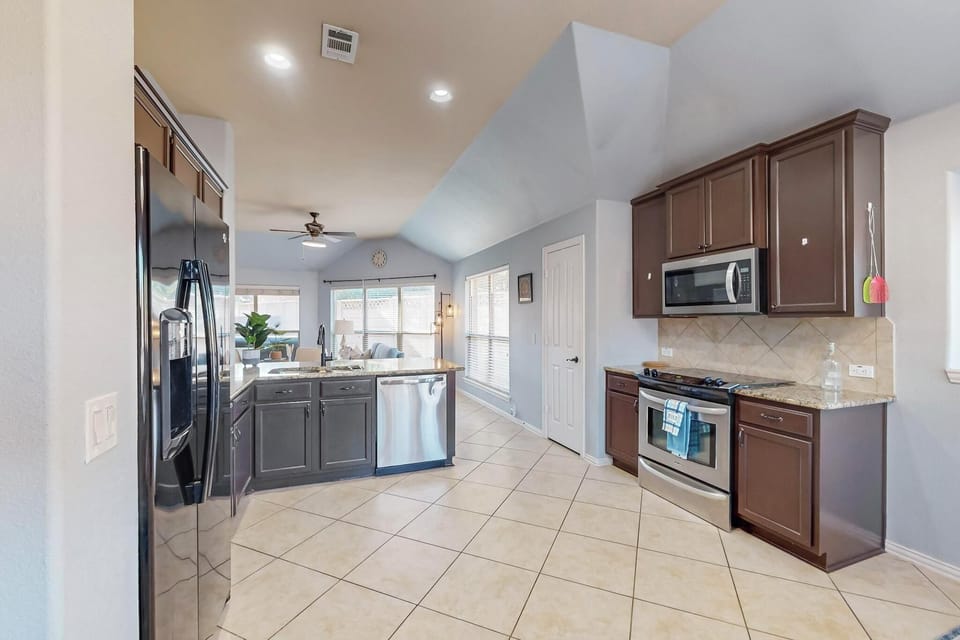 This open, modern kitchen offers everything you need to prepare your favorite meals. Stainless steel appliances, granite countertops, and ample cabinet space make cooking a pleasure during your stay.
