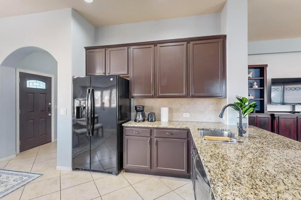 A fully equipped kitchen featuring sleek granite countertops, modern appliances, and ample cabinet space for all your culinary needs during your stay.