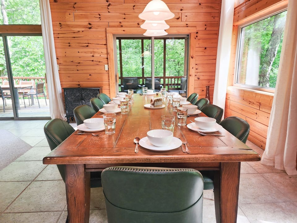 Pull everyone to the dining table before the night gets away — fits the whole group, natural light, and close enough to the kitchen that the food arrives hot.