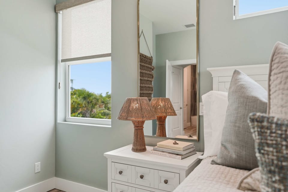 Cozy primary bedroom with soft coastal textures, warm woven accents, and natural light that creates a calm, relaxing retreat.