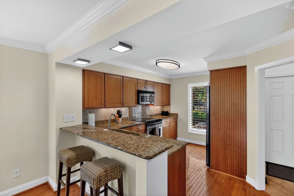 Your fully equipped kitchen features granite countertops, modern appliances, and a breakfast bar perfect for morning coffee or casual meals with loved ones.