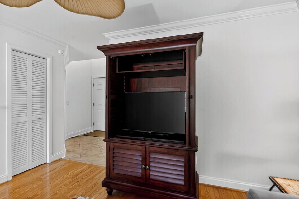 Your living space includes this custom entertainment center with a flat-screen TV, natural wood flooring, and stylish ceiling lighting to help you unwind after exploring.