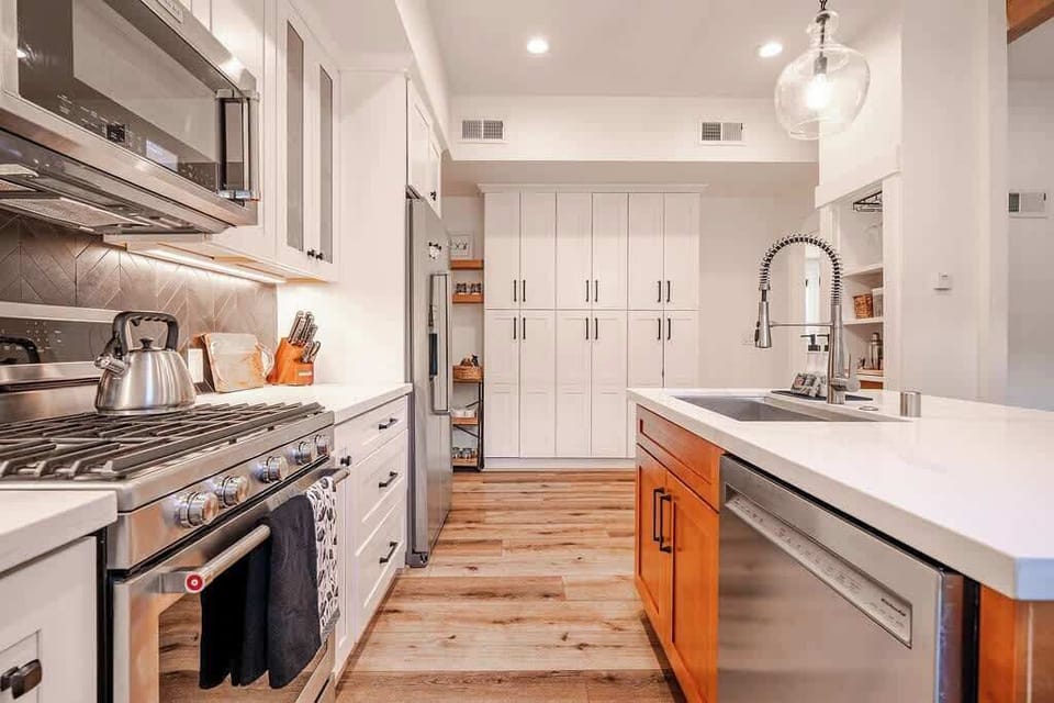 Kitchen: Drip coffee maker, blender, food processor, cooking utensils, and tableware