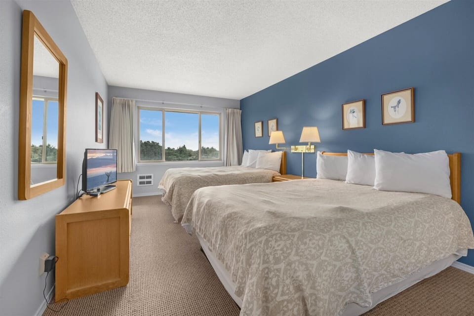 The bedroom houses two queen beds