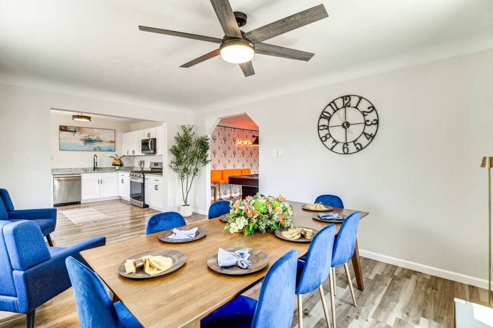 Set the table, pour the drinks, and let the meal happen. Blue velvet chairs, styled centerpiece, kitchen steps away, and clock on the wall reminding you there`s nowhere to be. This is what evenings together look like.