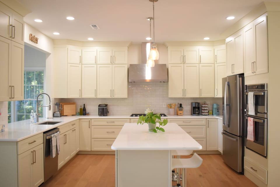 Bright gourmet kitchen with island seating and stainless steel appliances