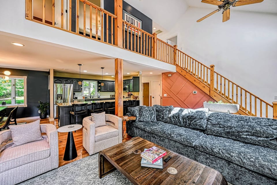 Open Living - A deep sectional and swivel chairs anchor the open living area beneath the loft, flowing into the kitchen.