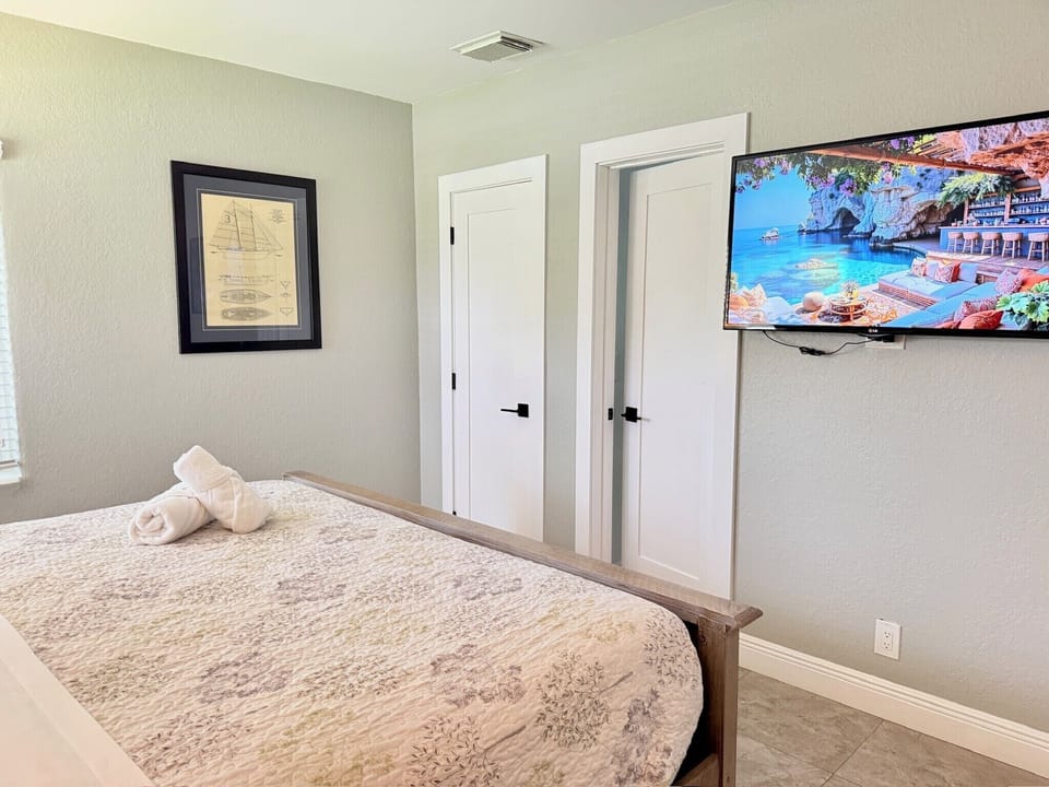 Bright, cozy bedroom with wall-mounted TV and clean modern finishes