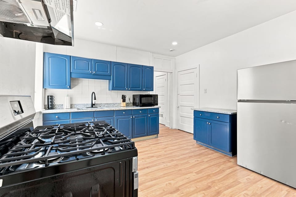Bright kitchen with bold blue cabinets, gas range, and plenty of prep space