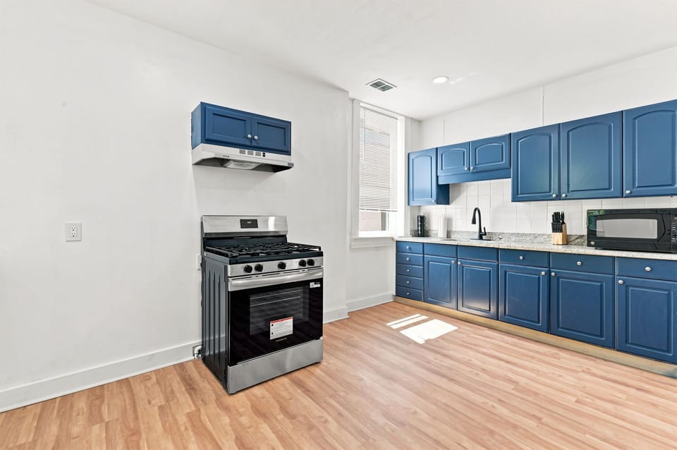 Bright modern kitchen with bold blue cabinets and stainless appliances