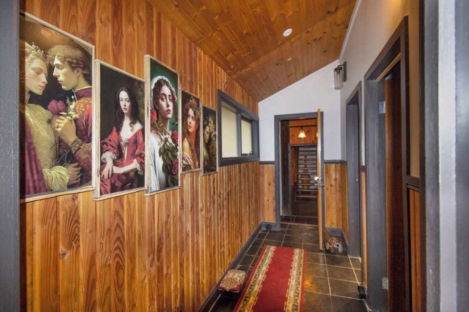 Warm wood-paneled hallway with striking art and cozy lodge-style charm