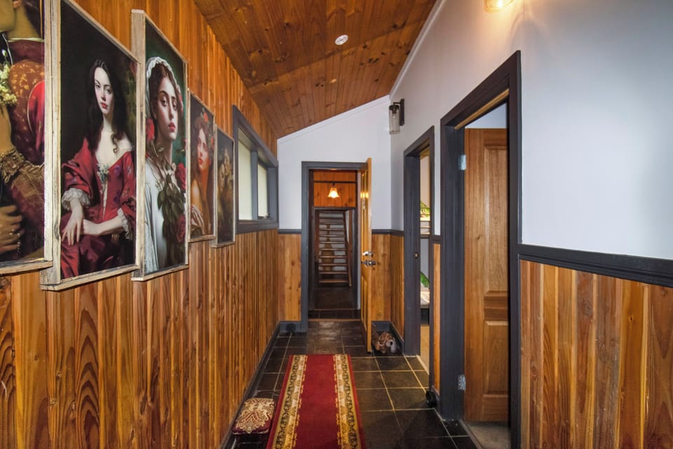 Warm wood-paneled hallway with curated art and cozy lodge-style charm