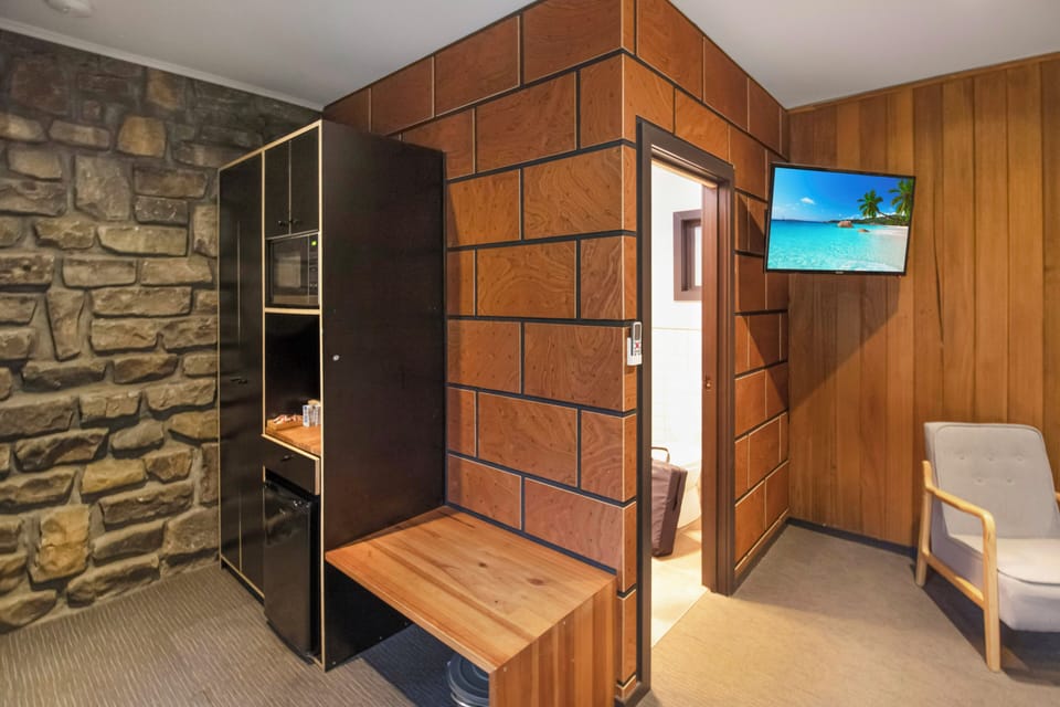 Cozy cabin-style nook with kitchenette, TV, and rustic stone accents
