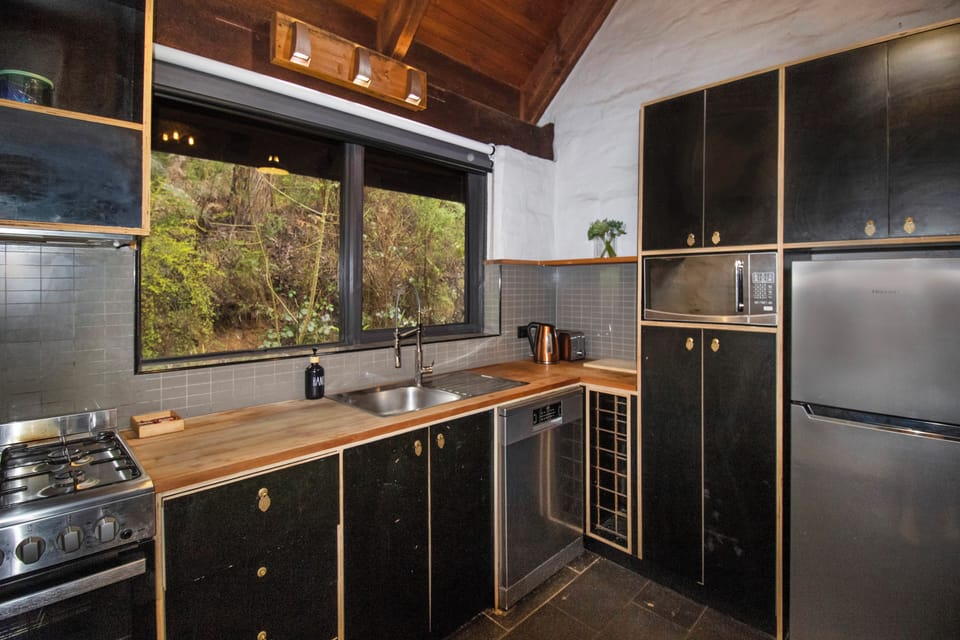 Cozy modern kitchen with forest views, full appliances, and warm wood accents