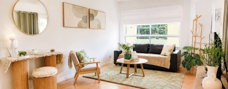 Bright, stylish living room with natural light, greenery, and cozy seating