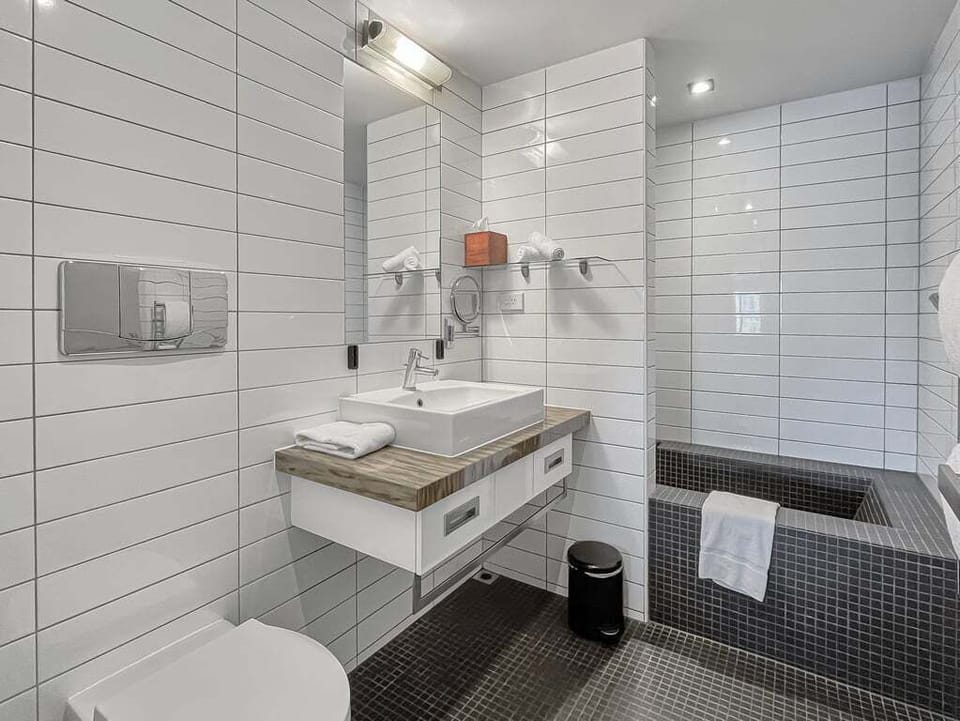 Modern bathroom featuring sleek finishes and a bathtub.