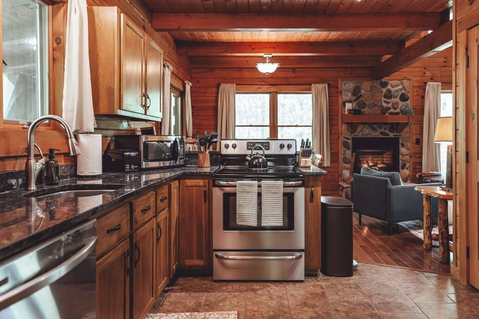 Well-stocked kitchen with cookware, utensils, cooking essentials (oils, spices), mixing bowls, and a slow cooker