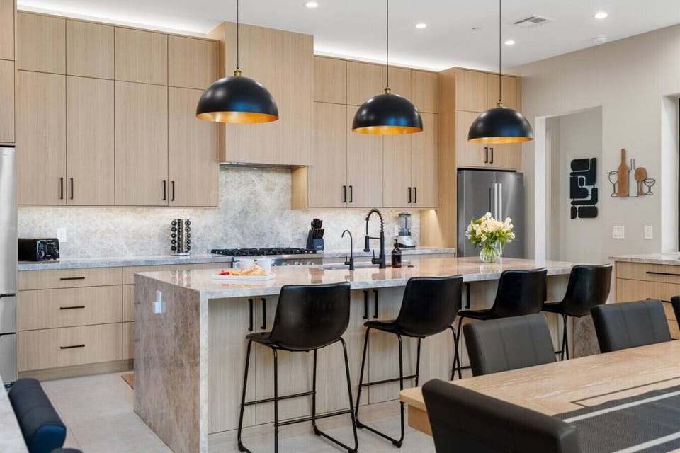 Chef`s kitchen with oak cabinets, quartzite countertops, and waterfall island.