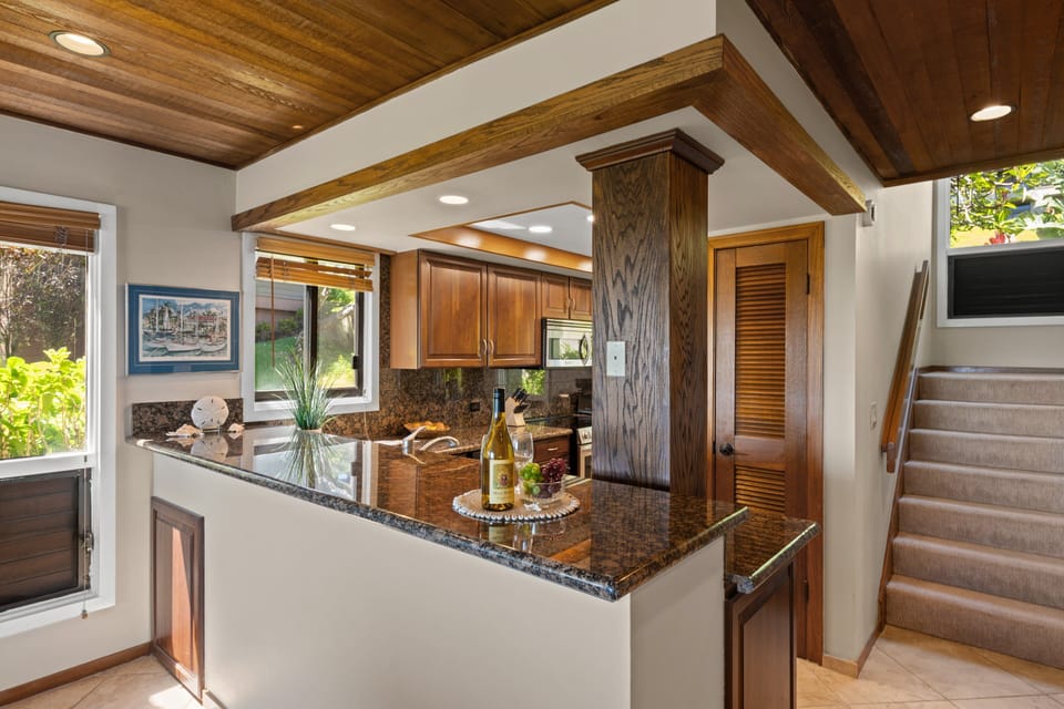 Functional kitchen layout featuring a granite bar counter and seamless flow into the rest of the home.