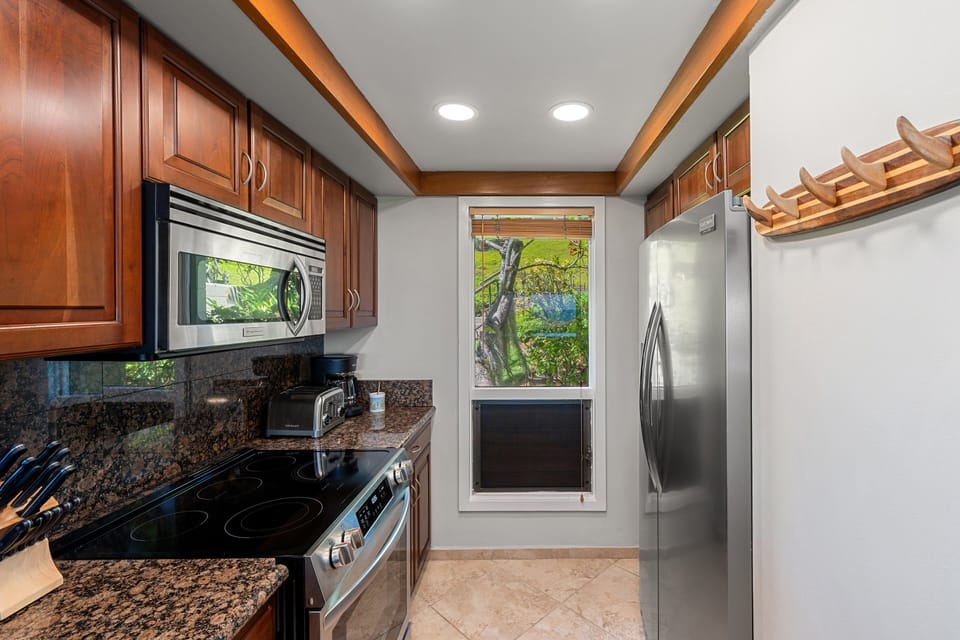 Well-equipped kitchen featuring modern appliances, rich wood cabinetry, and ample prep space.
