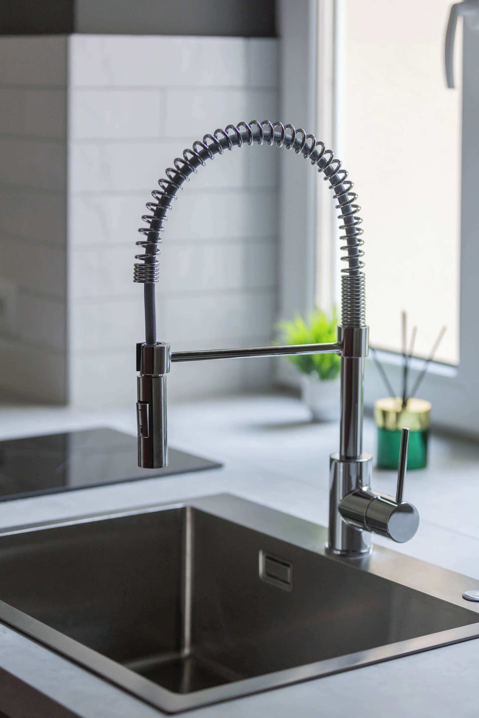 Modern black kitchen faucet and deep sink by the window