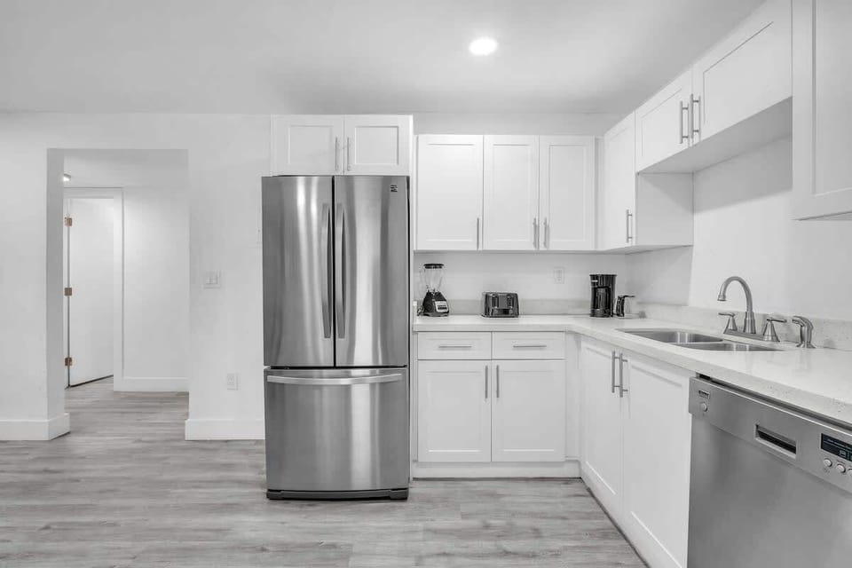 A sleek, clutter-free kitchen with all the necessary amenities, including a spacious refrigerator, dishwasher, and essential cooking tools.