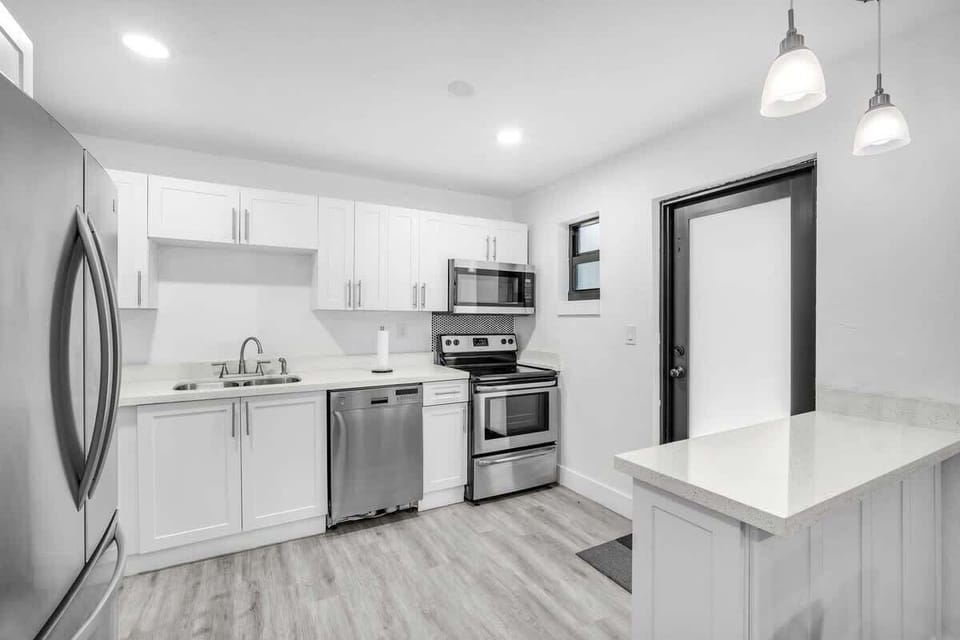 A sleek, clutter-free kitchen with all the necessary amenities, including a spacious refrigerator, dishwasher, and essential cooking tools.