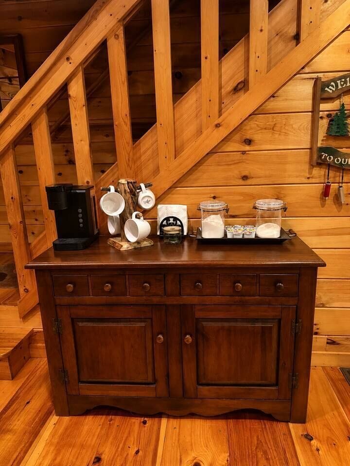 Coffee area with Keurig, mugs, coffee, cream and sugar. 